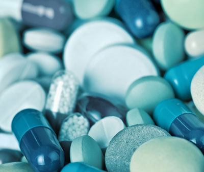 Image of pharmaceutical tablets and capsules, all shades of blue.